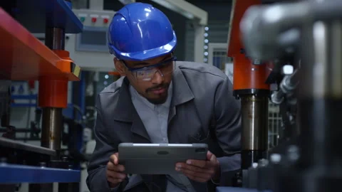 Engineer holding a tablet while checking and controlling the working machine Stock Footage 296285338