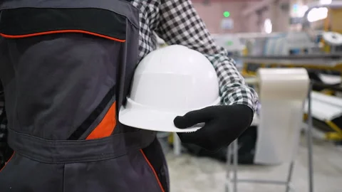 Engineer holding white hard hat in a factory Stock Footage 314582848
