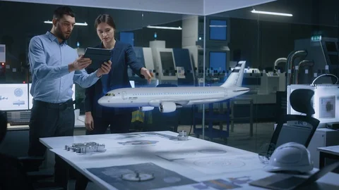 Engineer Holds Tablet Computer, Showing Augmented Reality Airplane to aemale Stock Footage 128854444