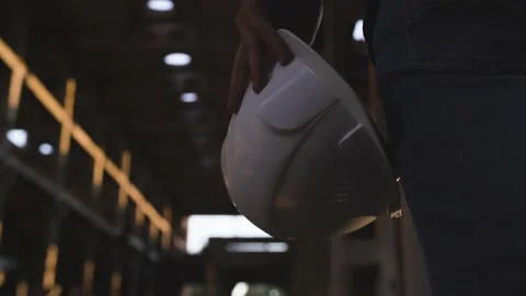 An engineer holds a white helmet in his hand at a construction site Stock Footage 138211824