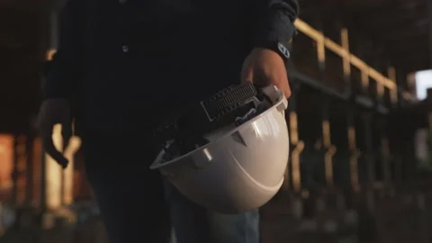 An engineer holds a white helmet in his hand at a construction site Stock Footage 138211924