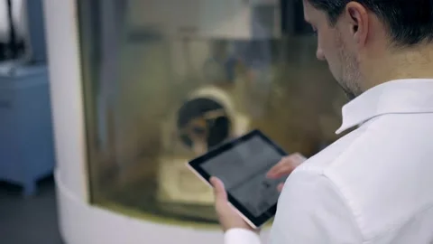 An engineer at an industrial plant. A worker controls the operation of a CNC Stock Footage 171775006