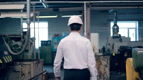 An engineer at an industrial plant. A worker controls the operation of a CNC Stock Footage 171775426