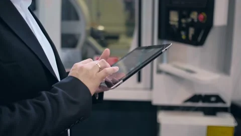 An engineer at an industrial plant. A worker controls the operation of a CNC Stock Footage 172014685
