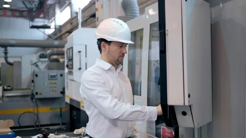 An engineer at an industrial plant. A worker controls the operation of a CNC Stock Footage 172014785