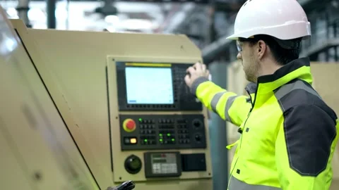 An engineer at an industrial plant. A worker controls the operation of a CNC Stock Footage 172016802