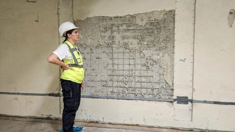 Engineer inspecting cracked wall structure at industrial site Stock Photos