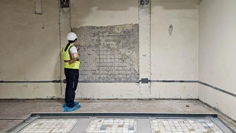 Engineer inspecting cracked wall structure at industrial site Stock Photos