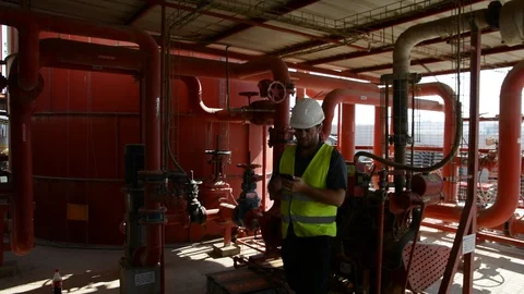 Engineer inspecting machinery water pump. checks the pump sprinklers Stockbeeldmateriaal 115044063