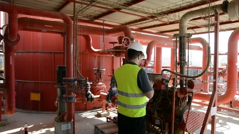 Engineer inspecting machinery water pump. checks the pump sprinklers Видео 115044085