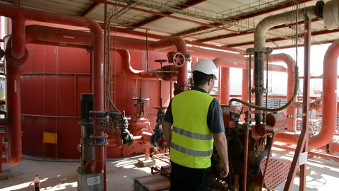 Engineer inspecting machinery water pump. checks the pump sprinklers Видео 115044102
