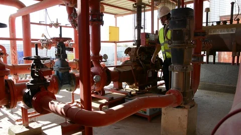 Engineer inspecting machinery water pump. checks the pump sprinklers Видео 115045092