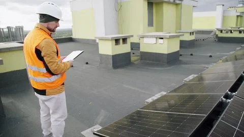 Engineer inspecting solar panels on residential rooftop. Vídeo Stock 331299334