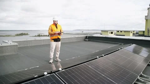 Engineer inspecting solar panels on residential rooftop. Vídeo Stock 331299344
