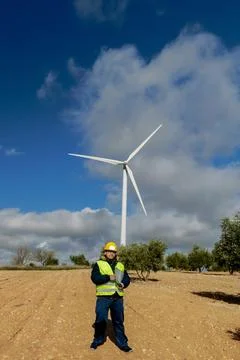 Engineer inspecting wind turbine for renewable energy generation Stock Photos