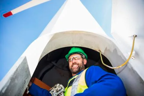 Engineer inspecting wind turbine, using wrench Foto stock
