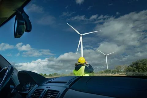 Engineer inspecting wind turbines in a wind farm from car Stock Photos