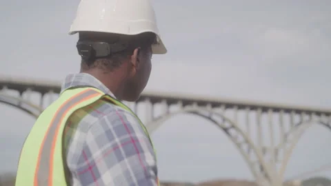 Engineer Inspects Bridge with Hard at and Saft Vest on Sunny Day Stock Footage 208780366