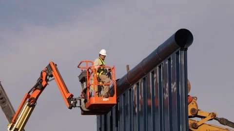 Engineer inspects large wall being built from forklift Stock Footage 111849057