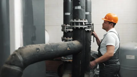 An engineer inspects a pipe connection at a factory. Stock Footage 306815203