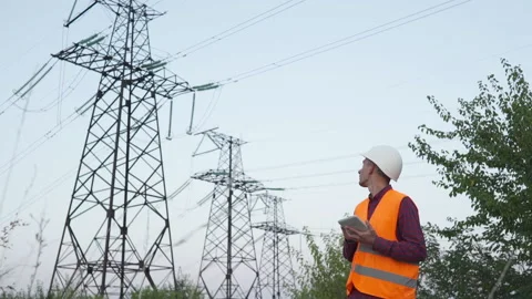 Engineer inspects a power line using data from electric sensors on a tablet. Stock Footage 140191409