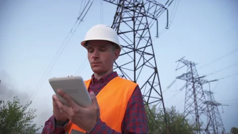 Engineer inspects a power line using data from electric sensors on a tablet. Stock Footage 202181424