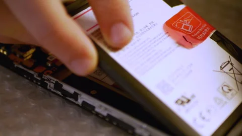 The engineer installs the battery into the phone Stock Footage 246034817