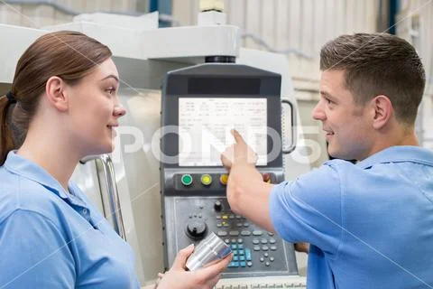 Engineer Instructing Female Apprentice On Use Of CNC Machine 스톡 사진