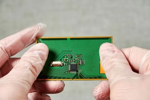An engineer keeps PCB with a microchip in his hands after development Stock Photos