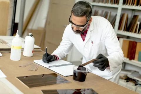 Engineer in the laboratory examines ceramic tiles Stock Photos