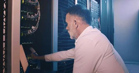 Engineer, laptop and cable connection at data center for network test Stock Photos