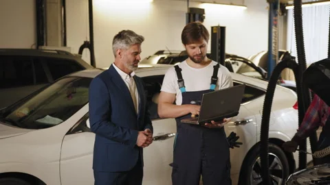 Engineer with laptop makes computer diagnostics of the car engine in auto Stock Footage 243361372