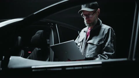 Engineer with Laptop with Modern Electric Car Stock Footage 233885830