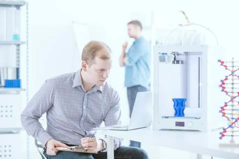 Engineer with laptop testing printer Stock Photos