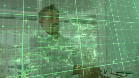 Engineer leaning over desk, reacting to green grid overlay, annotating plans, 库存影片 333901487