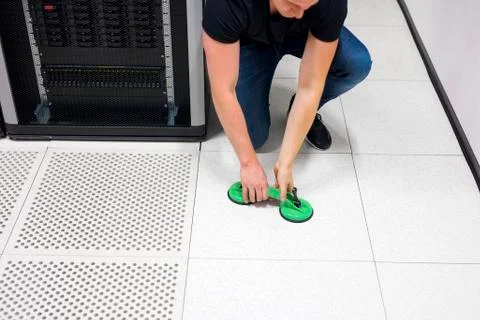 Engineer Lifting Floor Tile Using Vacuum Suction Cups In Datacen Stock Photos