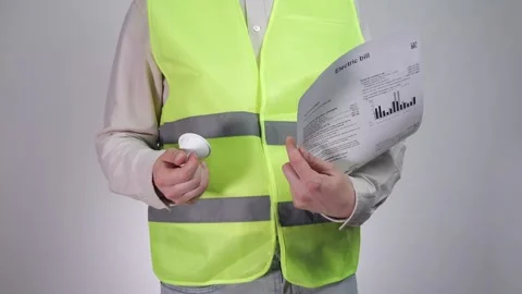 Engineer with a light bulb and an electricity bill. Stock Footage 310691774