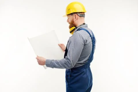 Engineer looking at a drawing on a white background. Stand back to camera. Stock Photos