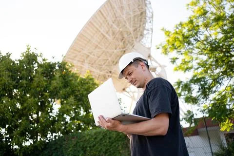 Engineer looking earth based astronomical radio telescope Foto stock
