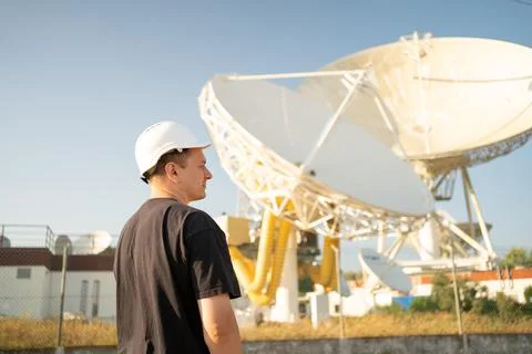 Engineer looking earth based astronomical radio telescope Stock Photos