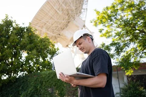 Engineer looking earth based astronomical radio telescope Foto stock