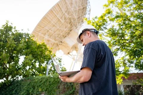 Engineer looking earth based astronomical radio telescope Foto stock