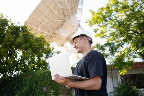 Engineer looking earth based astronomical radio telescope Stock-Fotos