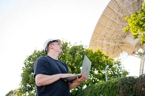 Engineer looking earth based astronomical radio telescope Foto stock