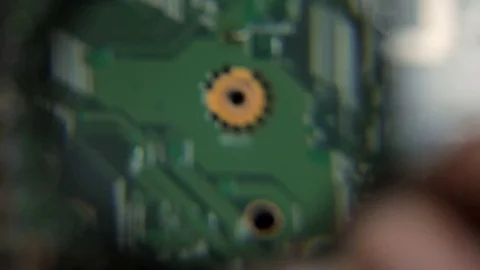 Engineer looking for a problem on motherboard laptop with a magnifying glass Stock Footage 79235952