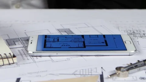Engineer looks at the drawings and graphics in the phone. Close up Stock Footage 73682271