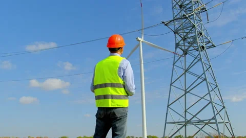 Engineer looks at rotating propeller near power lines Stock Footage 164109155