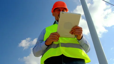 Engineer looks in tablet checking data under windmill 스톡 동영상 166808242