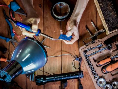 Engineer with magnifier in hands making a board with soldering iron Foto stock