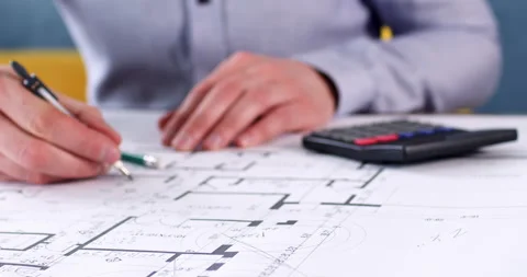 Engineer makes calculations and leaves notes on drawing Stockbeeldmateriaal 243826694